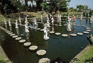 Tourists on pathway between statues Tirta Gangga Bali, Indonesia by Joanne Lane